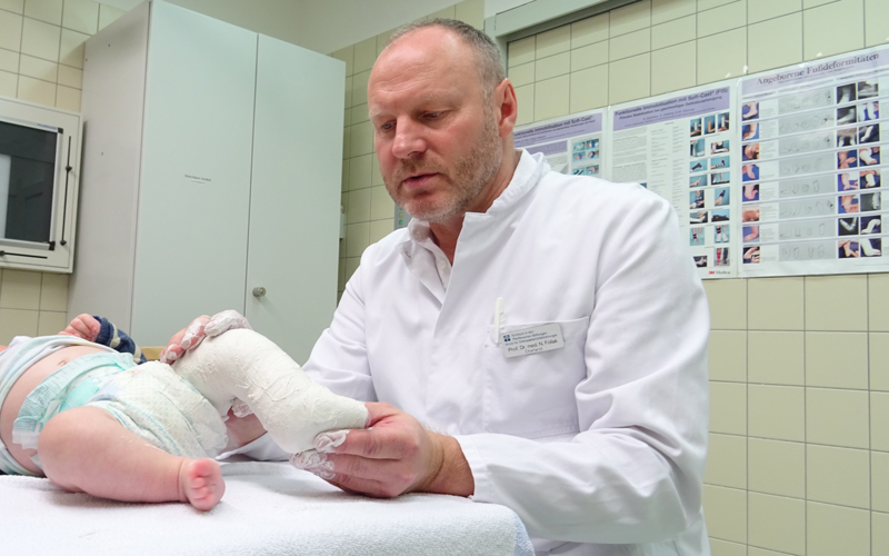 Dr. Niels Follak behandelt Säugling mit Klumpfüßen